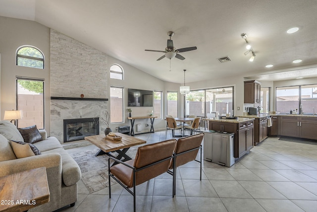 1461 W Tara Dr, Gilbert, AZ 85233 - living area with vaulted ceiling, a ceiling fan, a stone fireplace, and light tile patterned flooring