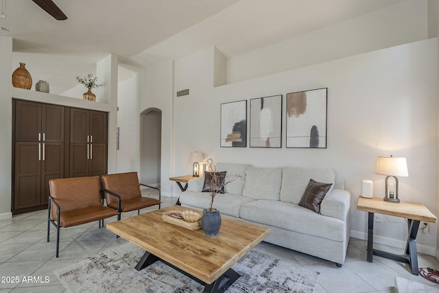 1461 W Tara Dr, Gilbert, AZ 85233 - living area featuring arched walkways, light tile patterned floors, baseboards, high vaulted ceiling, and a ceiling fan