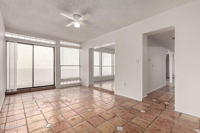 tiled empty room with a textured ceiling and ceiling fan