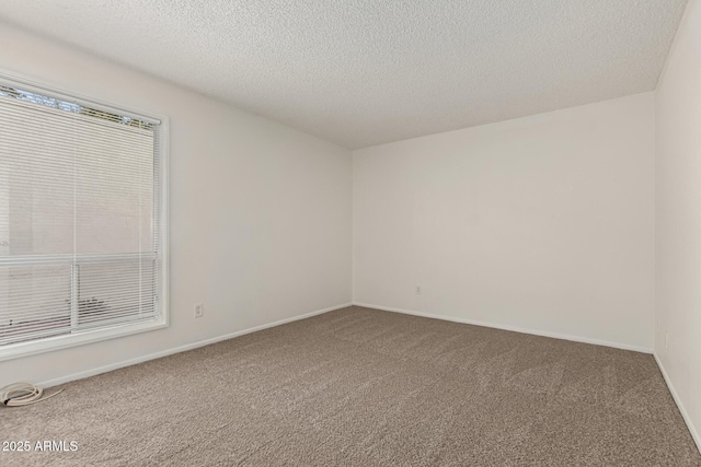 carpeted empty room featuring a textured ceiling