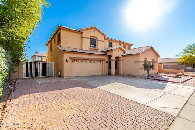 mediterranean / spanish-style home with stucco siding, a tiled roof, and decorative driveway