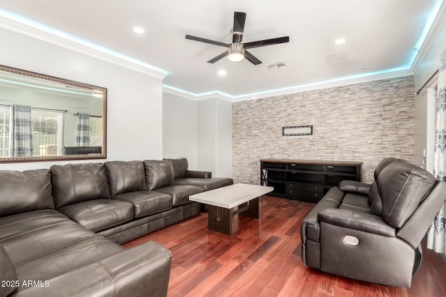 living room featuring crown molding, dark wood finished floors, a ceiling fan, visible vents, and recessed lighting