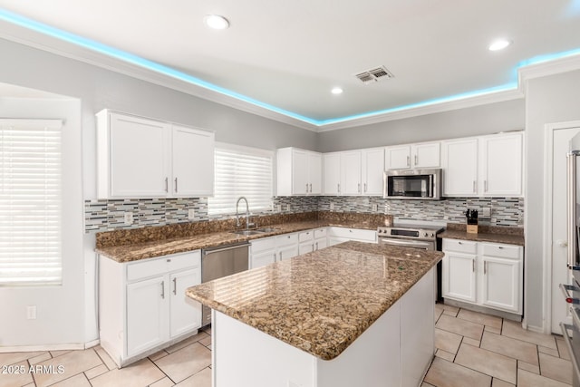 kitchen with a sink, visible vents, white cabinets, and appliances with stainless steel finishes