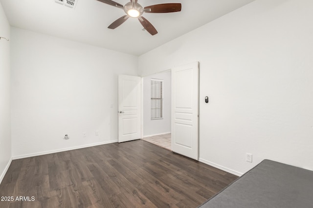 unfurnished bedroom with visible vents, baseboards, a ceiling fan, and wood finished floors
