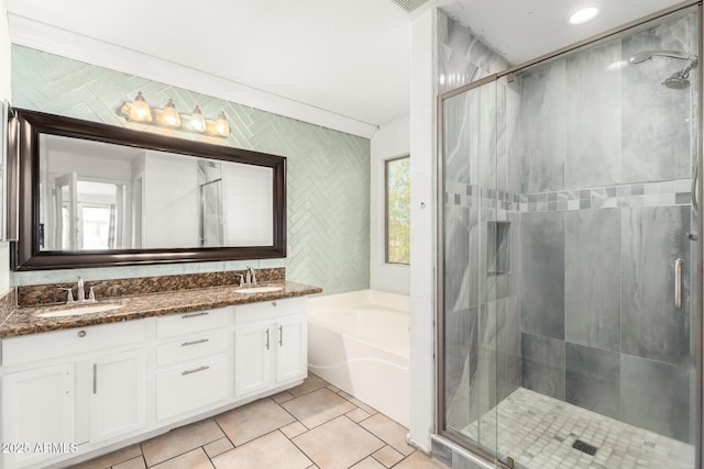 full bathroom featuring tile patterned flooring, a bath, a sink, and a stall shower