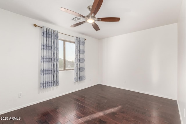 unfurnished room featuring dark wood-type flooring, baseboards, a ceiling fan, and visible vents