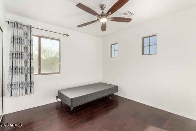 empty room featuring visible vents, ceiling fan, wood finished floors, and baseboards