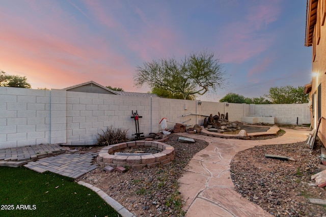 view of yard featuring a patio area, a fire pit, and a fenced backyard