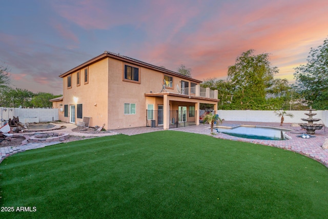 back of house featuring a patio area, a fenced backyard, a lawn, and stucco siding