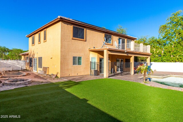 back of property with a patio area, stucco siding, a fenced backyard, and a lawn