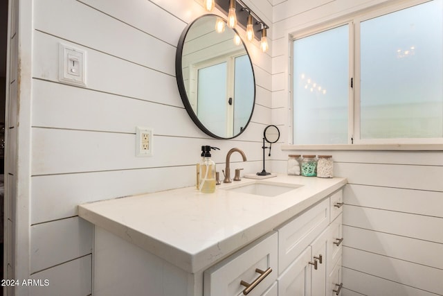 bathroom featuring vanity and wooden walls