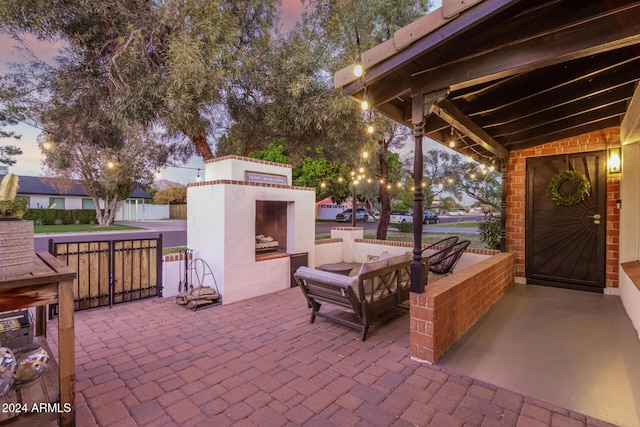 patio terrace at dusk featuring an outdoor living space with a fireplace