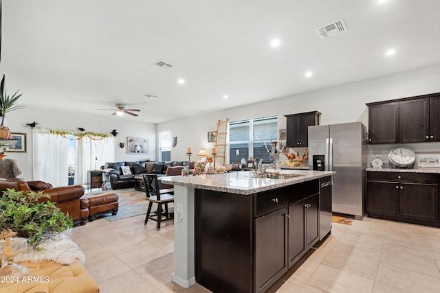 kitchen with ceiling fan, sink, a kitchen island with sink, dark brown cabinets, and appliances with stainless steel finishes