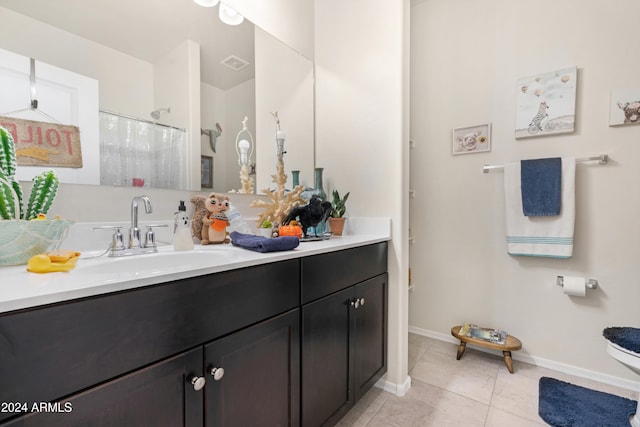 bathroom with toilet, vanity, tile patterned floors, and walk in shower