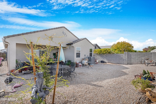 rear view of property featuring cooling unit and a patio area