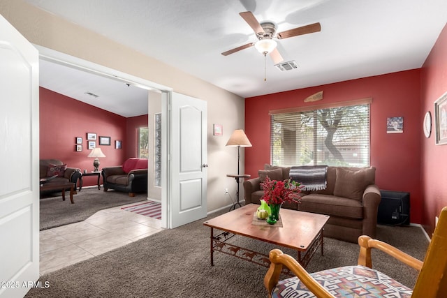 15994 W Bartlett Ave, Goodyear, AZ 85338 - living room with visible vents, a ceiling fan, light carpet, and light tile patterned floors