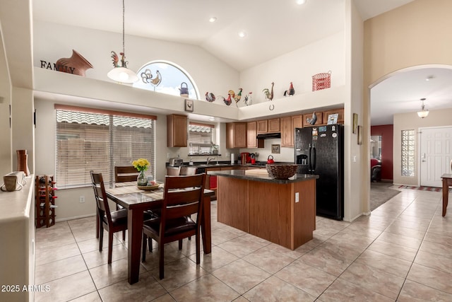 15994 W Bartlett Ave, Goodyear, AZ 85338 - kitchen featuring high vaulted ceiling, arched walkways, a center island, dark countertops, and black fridge with ice dispenser