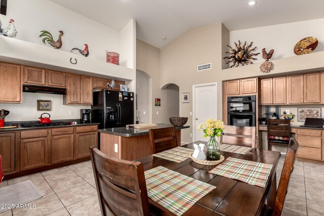 15994 W Bartlett Ave, Goodyear, AZ 85338 - dining area with light tile patterned floors, visible vents, arched walkways, recessed lighting, and high vaulted ceiling