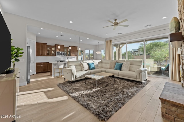 living room featuring ceiling fan and a healthy amount of sunlight