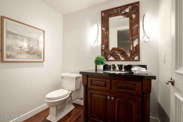 bathroom with hardwood / wood-style floors, vanity, and toilet