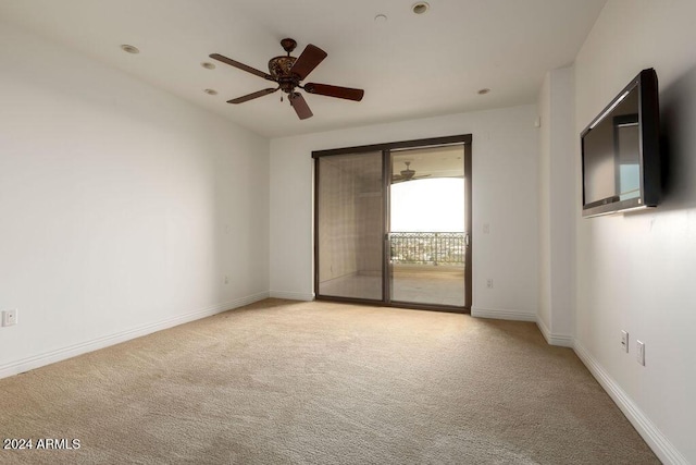 carpeted spare room featuring ceiling fan