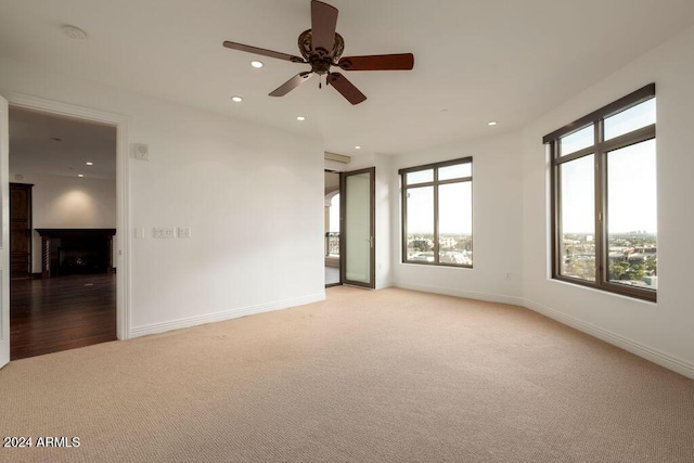 carpeted spare room featuring ceiling fan