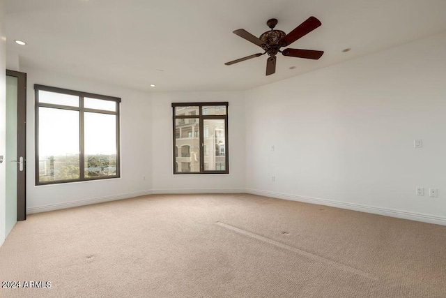 unfurnished room featuring light colored carpet and ceiling fan