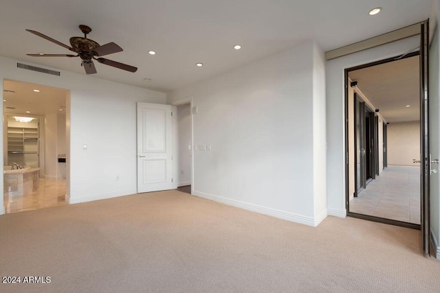 unfurnished room featuring light carpet and ceiling fan