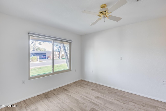 spare room with ceiling fan and light wood-type flooring