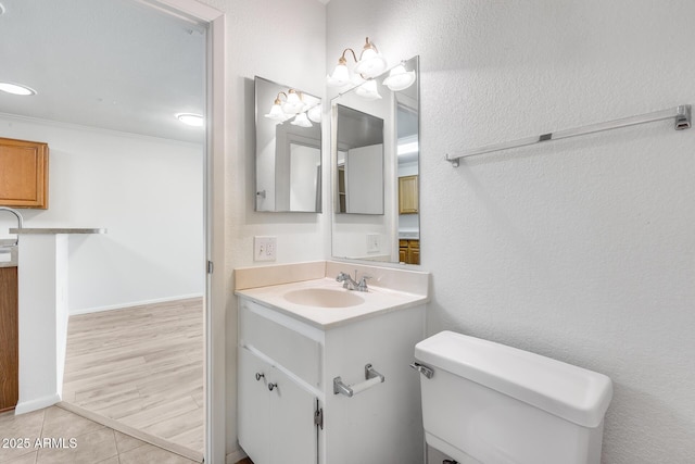 bathroom featuring tile patterned flooring, vanity, toilet, and ornamental molding