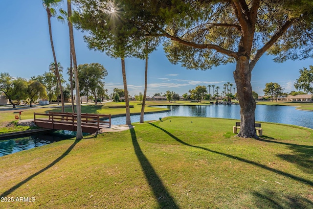 view of property's community featuring a lawn and a water view