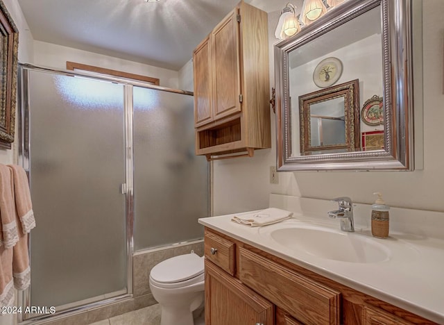 bathroom featuring tile patterned flooring, walk in shower, toilet, and vanity