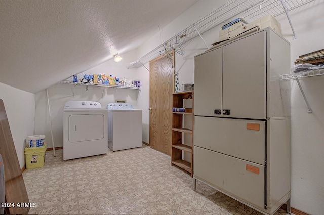 laundry room with a textured ceiling and washer and clothes dryer