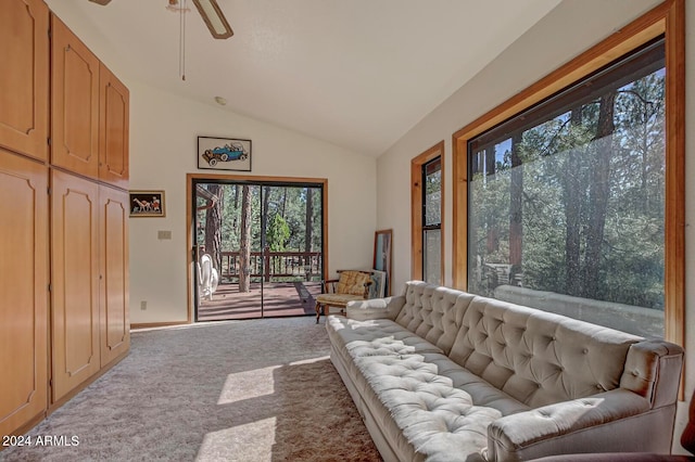 carpeted living room featuring a wealth of natural light, ceiling fan, and lofted ceiling