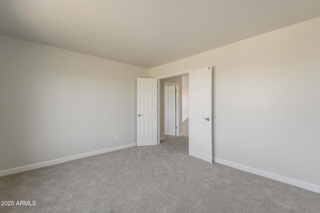 empty room featuring baseboards and carpet floors