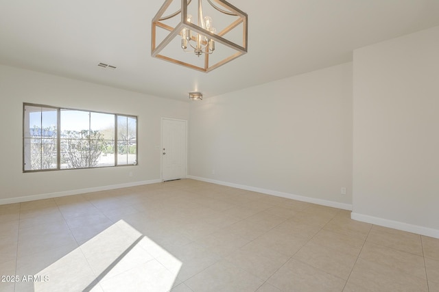 tiled spare room with visible vents, baseboards, and a notable chandelier