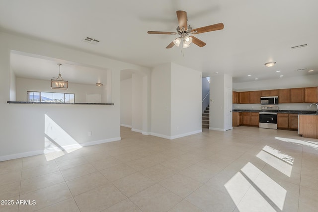 unfurnished living room featuring stairs, baseboards, and visible vents