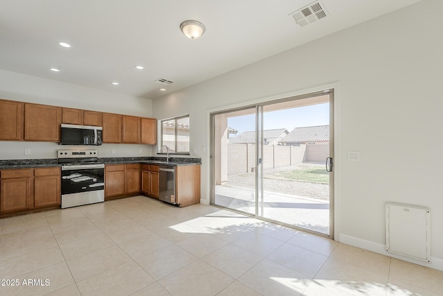 kitchen featuring visible vents, brown cabinets, stainless steel appliances, and a sink