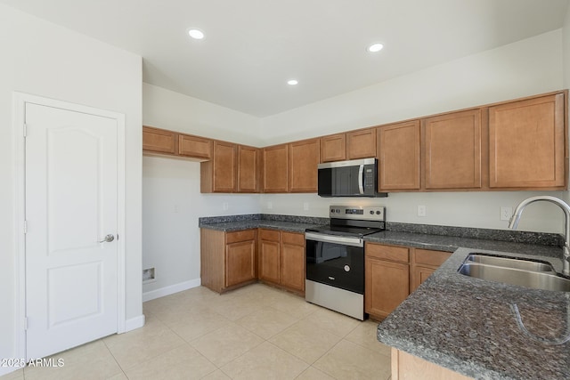 kitchen with a sink, appliances with stainless steel finishes, and brown cabinetry