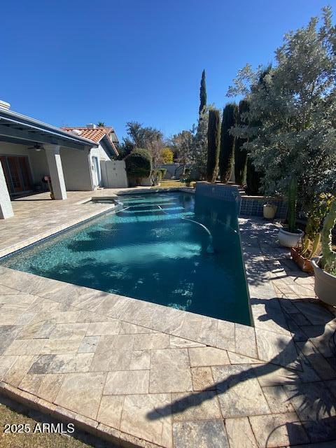 pool with a patio area, a ceiling fan, and a fenced backyard