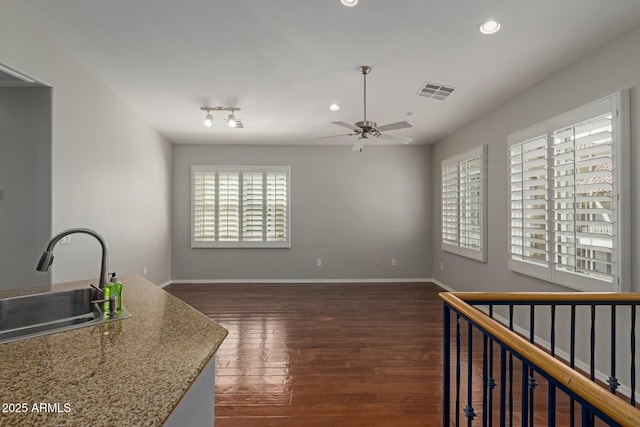 interior space featuring visible vents, a healthy amount of sunlight, ceiling fan, and hardwood / wood-style floors