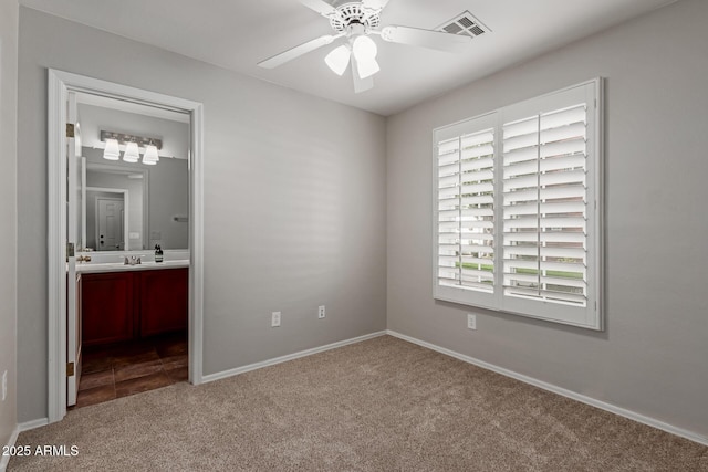 unfurnished bedroom with visible vents, a ceiling fan, ensuite bath, carpet, and baseboards