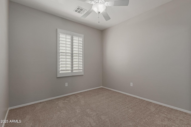 carpeted spare room featuring visible vents, baseboards, and a ceiling fan