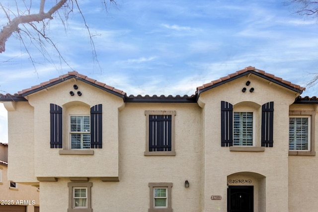 view of front of house with stucco siding and a tile roof