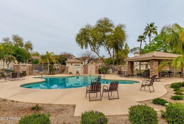 pool with a patio area and fence