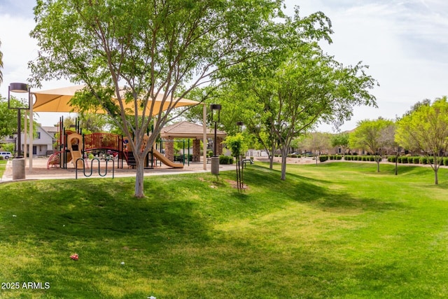 view of home's community with playground community and a yard