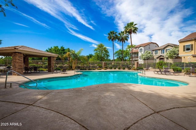 pool with a patio area and fence