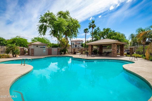 pool with a gazebo, a patio, and fence