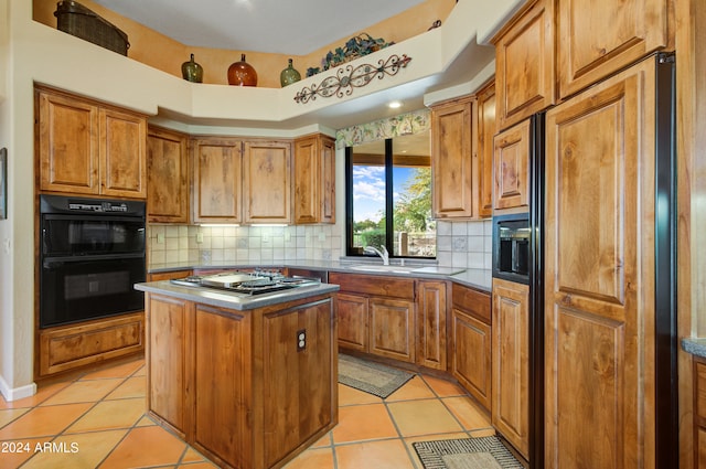 kitchen with stainless steel gas stovetop, a center island, light tile patterned floors, and black double oven