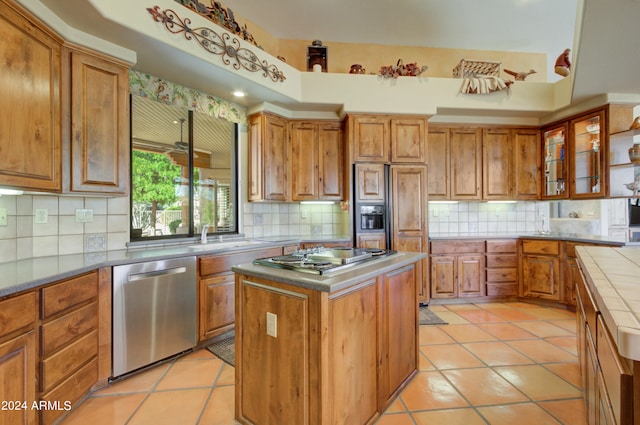 kitchen featuring backsplash, stainless steel appliances, light tile patterned floors, and a kitchen island